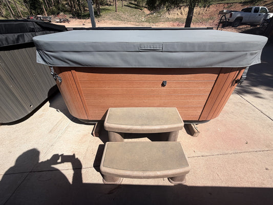 Refurbished Bullfrog Spa with cedar-tone cabinet, grey cover and matching steps