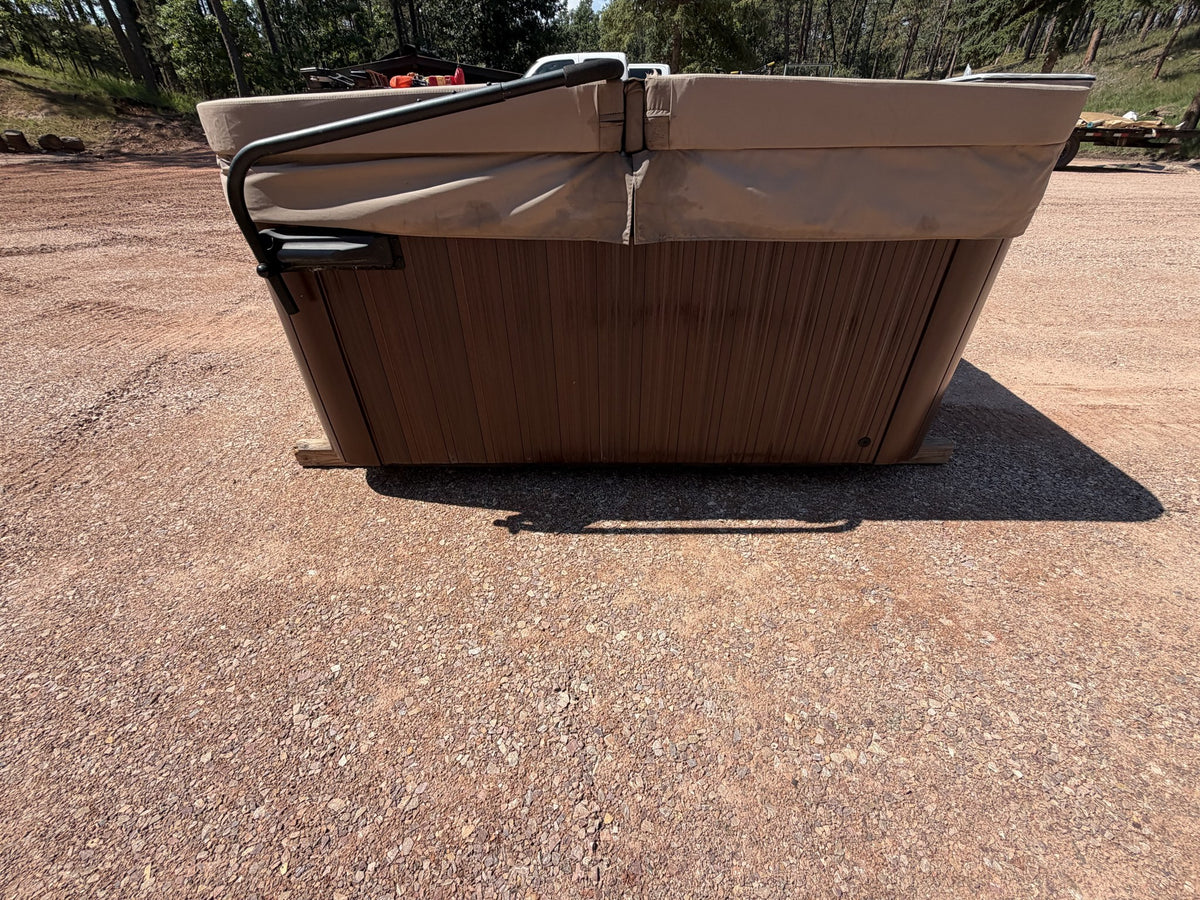 Corner view of the Jacuzzi J-245 hot tub showing cabinet and cover lifter bar