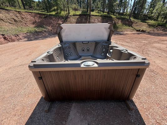 Refurbished Jacuzzi J-245 hot tub with cover open, showing the open seating layout and jetted foot dome