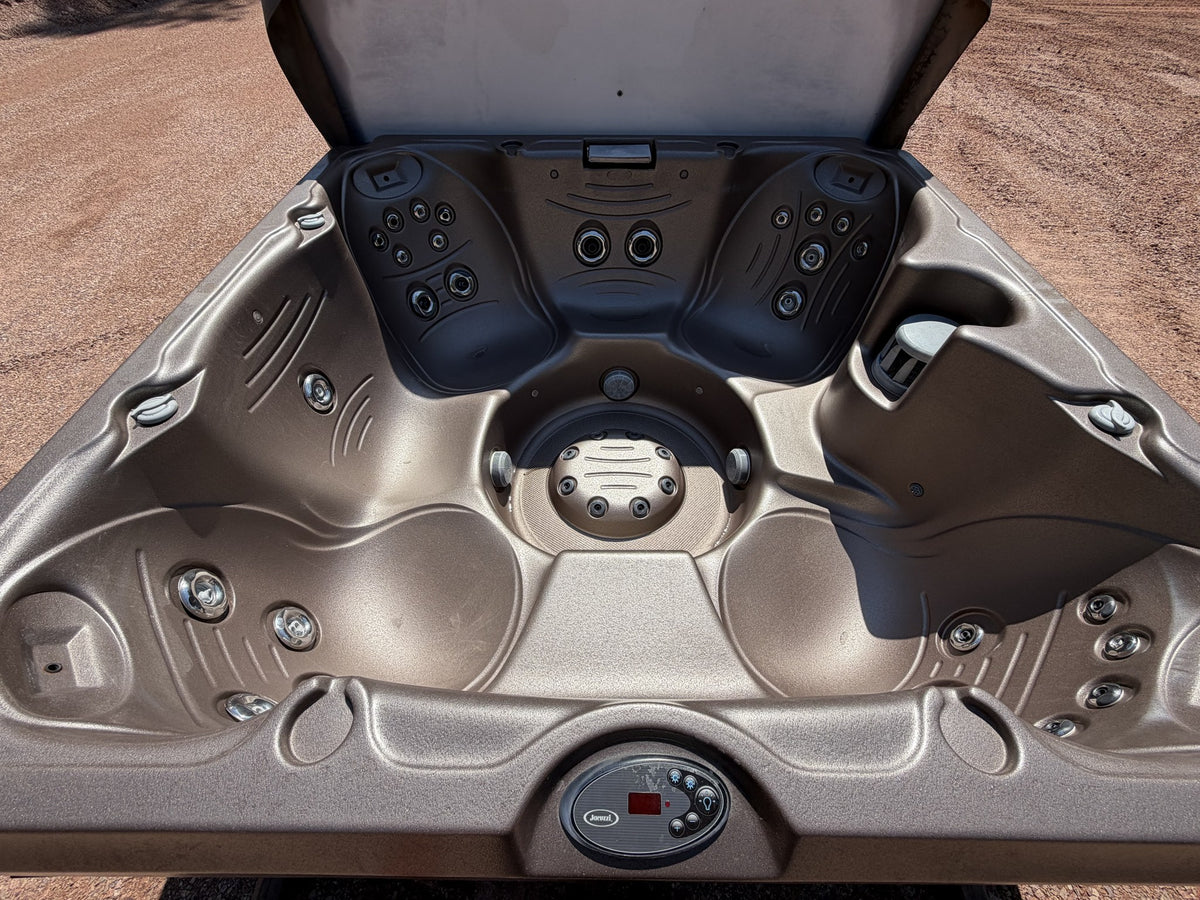 Interior of the Jacuzzi J-245 showing stainless steel jets, therapy seats, foot dome and topside control panel