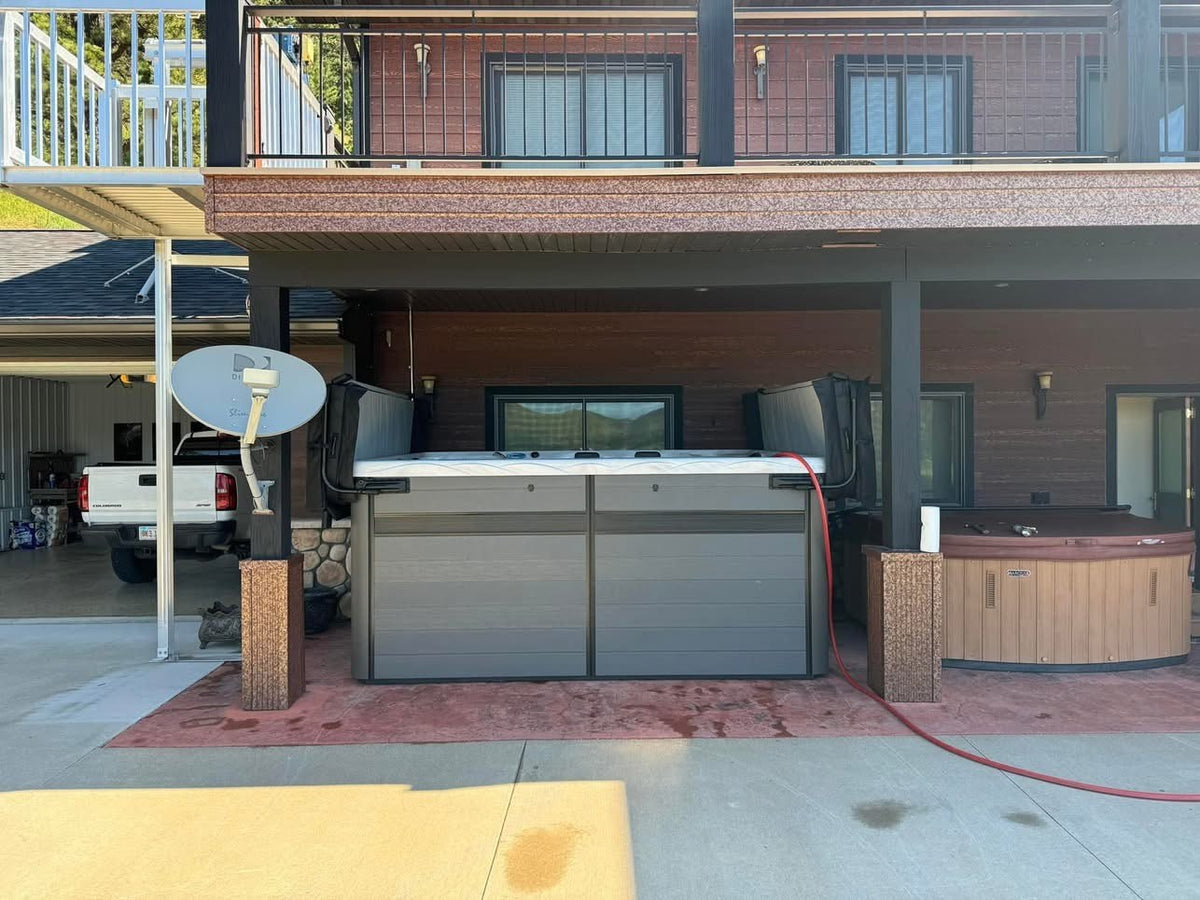 Exterior of the H2X Therapool Deep showing the driftwood grey cabinet and two-piece cover on the patio